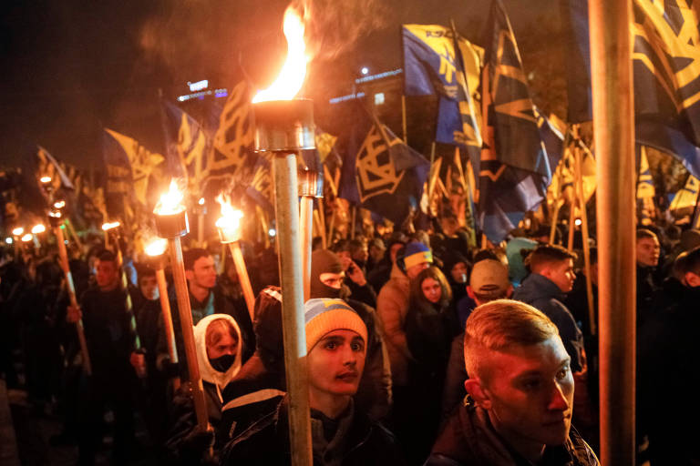 Membros de dois grupos extremistas da Ucrânia, o Batalhão Azov e o Setor Direito, reunidos durante manifestação em Kiev; nas bandeiras empunhadas, está o símbolo de um tridente, brasão do país