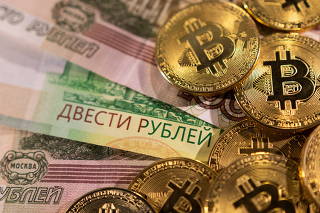 Illustration shows Russian rouble banknotes and representations of the cryptocurrency Bitcoin