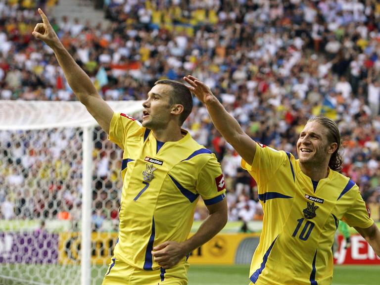 Apontando com o dedo indicador da mão direita para o alto, Shevchenko, que usa a camisa 7, e Voronin, que usa a camisa 10, festejam a vitória da Ucrânia contra a Tunísia na Copa do Mundo da Alemanha, em 2006