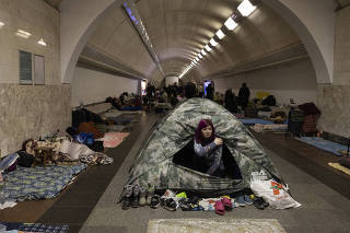 Taria, 27, pops out of a tent where she is living with her two children in a subway station, where many of them have resided for about a week, in Kyiv, Ukraine, March 2, 2022.  (Lynsey Addario/The New York Times)