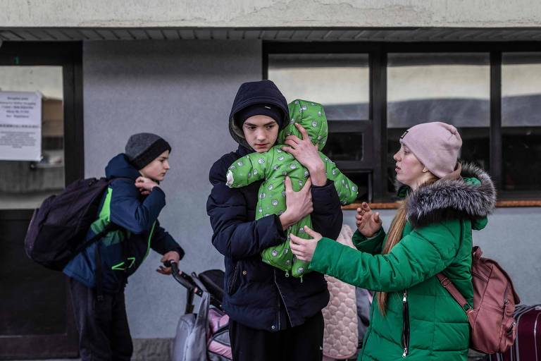 Refugiados ucranianos chegam à cidade polonesa de Korczowka, junto à fronteira dos dois países