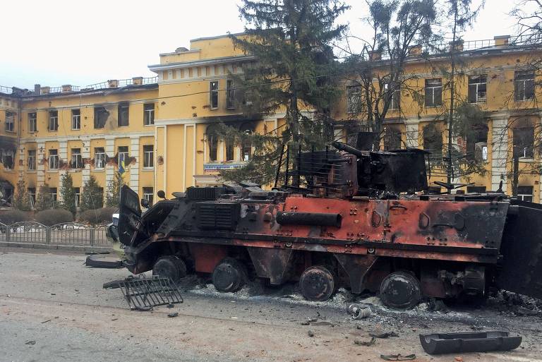 Tanque ucraniano destruído em frente a um escola da cidade de Kharkiv; o prédio escolar também foi alvo do bombardeio russo 
