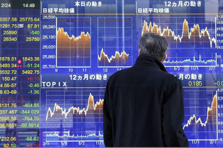 Homem olha para painel de índices Nikkei