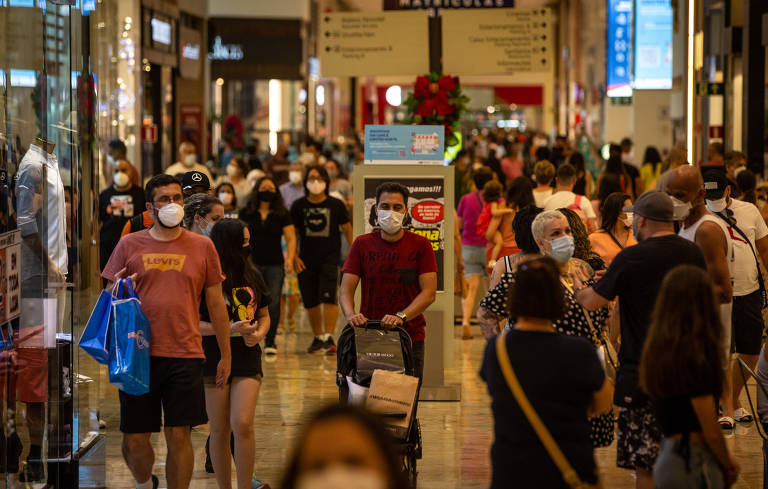 Movimentação de pessoas usando máscara de proteção em corredor de shopping center