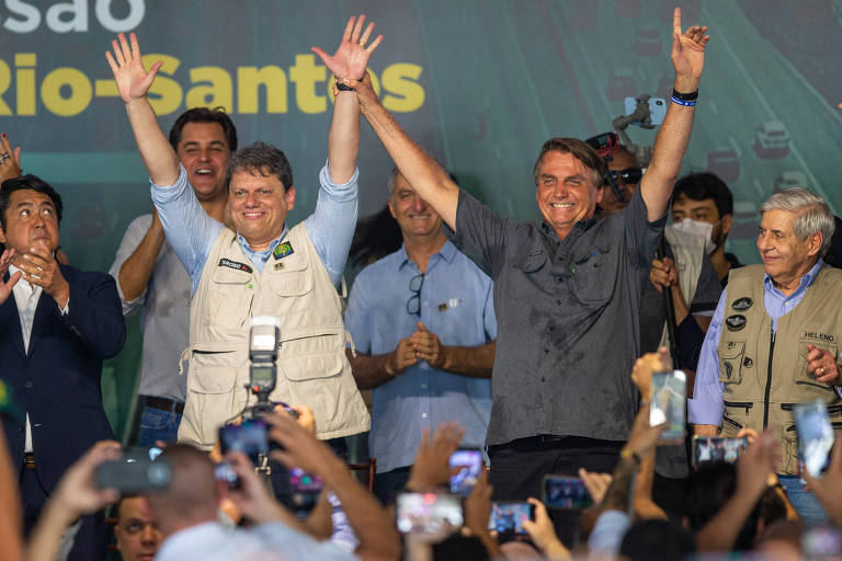 Jair Bolsonaro levanta a mão de Tarcísio de Freitas, em evento da concessão da via Dutra