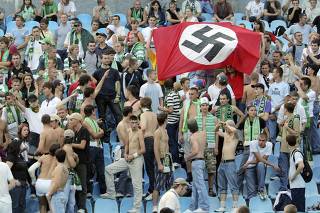 Supporters of Karpaty Lviv hold a German Nazi flag with a swastika as they attend a soccer match against Dynamo Kiev in Kiev