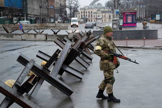 A member of the Territorial Defence Forces guards a checkpoint in central Kyiv