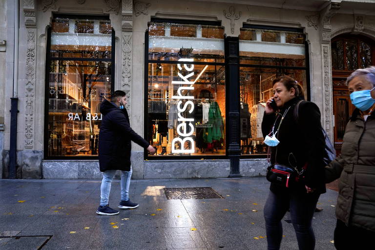 fachada de loja de roupas em que se lê em branco Bershka, com pedestres na calçada
