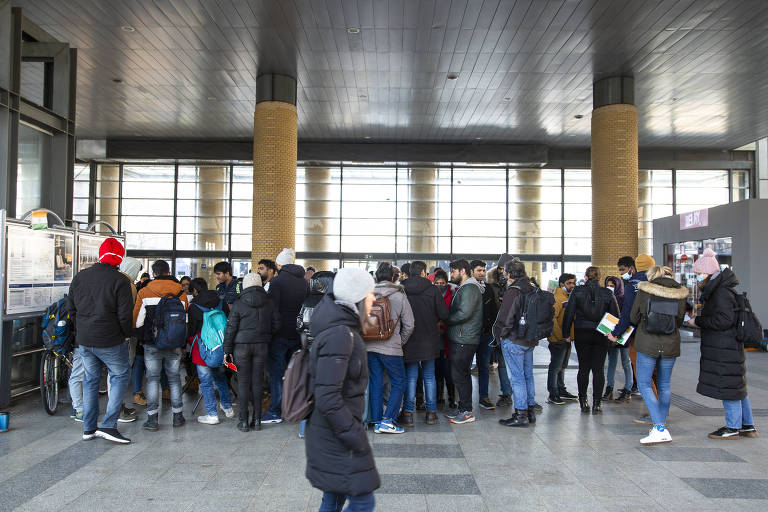 Estudantes que chegaram da Ucrânia apresentam seus passaportes na estação de trens de Budapeste