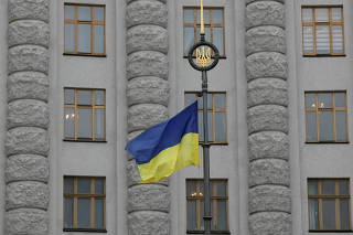 FILE PHOTO: A Ukrainian national flag flies in front of government building in central Kiev