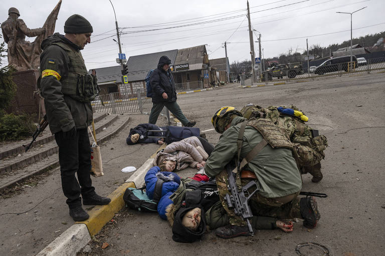Soldados ucranianos tentam ajudar família de Serguei Perebinis em Irpin; o homem que acompanhava sua esposa e filhos era um amigo da família