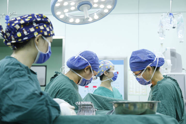 Cirurgiãs operam um paciente em um hospital
