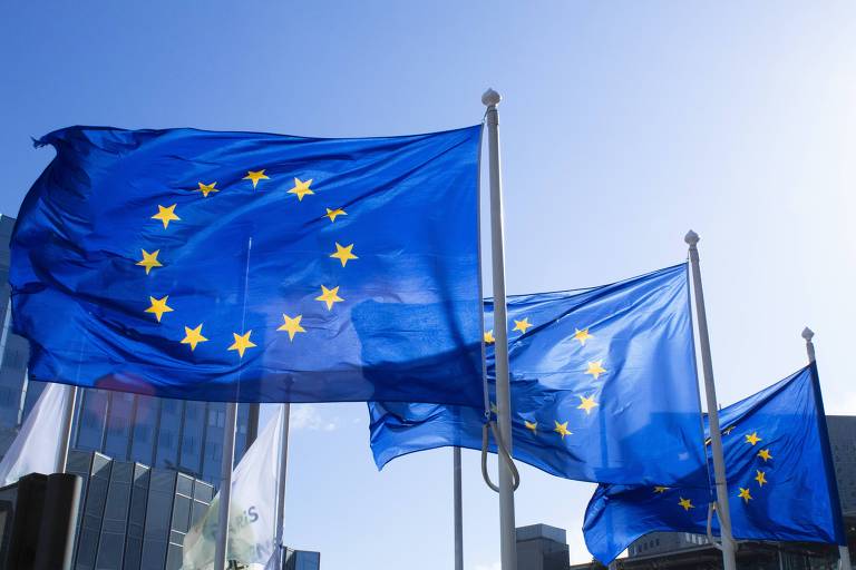 Foto mostra três bandeiras da União Europeia. Elas são azul, com estrelas formando um círculo.