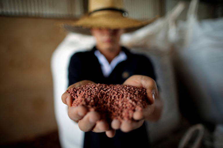 Trabalhador mostra fertilizante usado em fazenda de soja perto de Brasília
