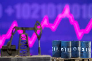 FILE PHOTO: FILE PHOTO: Models of oil barrels and a pump jack are displayed in front of a rising stock graph and 