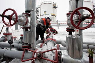 FILE PHOTO: A worker turns a valve at UdmurtNeft's Gremikhinskoye oil field east of Izhevsk