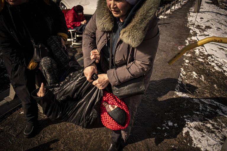 Voluntários atuam na retirada de idosos, com dificuldades para se locomoverem, da cidade de Irpin, nos arredores de Kiev