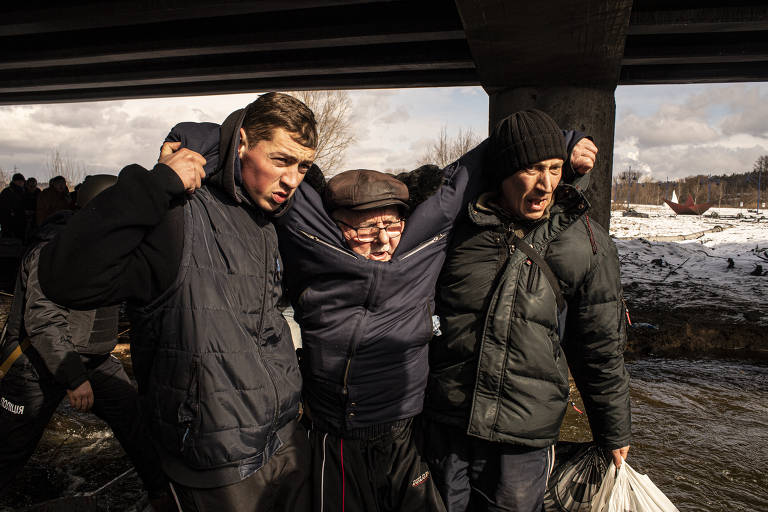 Voluntários atuam na retirada de idosos, com dificuldades para se locomoverem, da cidade de Irpin, nos arredores de Kiev