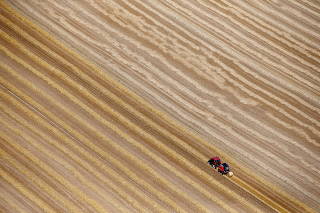 FILE PHOTO: An aerial view shows a French farmer in his tractor making bales of straw after wheat harvest in his field in Coquelles near Calais