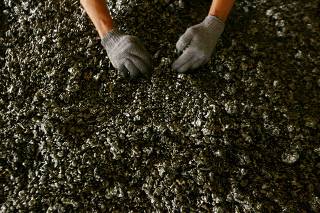 FILE PHOTO: A worker displays nickel ore in a ferronickel smelter owned by state miner Aneka Tambang Tbk at Pomala district in Indonesia
