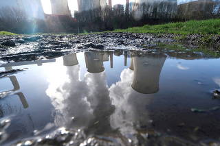 FILE PHOTO: The lignite (brown coal) power plant complex of German energy supplier and utility RWE is reflected in a large puddle in Neurath, northwest of Cologne, Germany