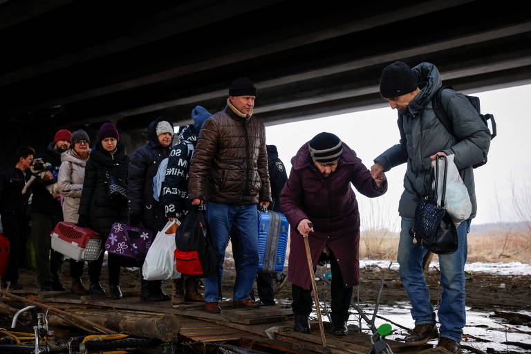 Moradores atravessam rio durante retirada de civis da cidade de Irpin, na região de Kiev