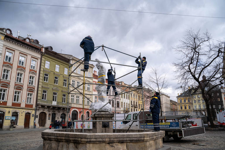 Trabalhadores instalam proteção para estátua em praça de Lviv