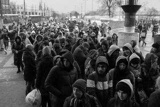 Refugees queue for trains to Poland following the Russian invasion of Ukraine, at the train station in Lviv