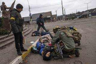 Moments after four civilians trying to evacuate were hit by Russian mortar fire, Ukrainian soldiers try to save Anatoly Berezhnyi Ñ the only one who still had a pulse Ñ in Irpin, west of Kyiv, on Sunday, March 6, 2022. (Lynsey Addario/The New York Times)