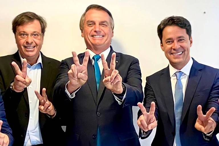 O presidente Jair Bolsonaro ao lado do ministro do Turismo, Gilson Machado (esq.), e do prefeito de Jaboatão dos Guararapes, Anderson Ferreira (dir.). Todos fazem sinal de V de vitória com as mãos
