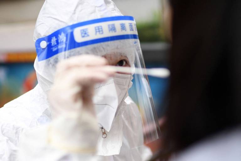 Profissional de saúde recolhe amostra para fazer teste de Covid em Wuhan, na China