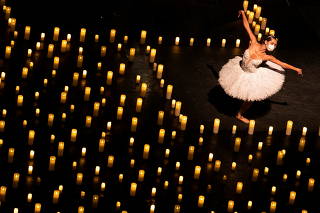Ballet dancers perform among candles in Sao Paulo
