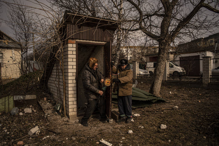 Moradores de Barishivka tentam consertar a porta de um bunker horas depois do bombardeio