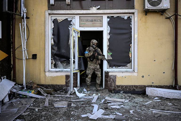 Soldado ucraniano deixa prédio atingido por bombardeio russo em Kiev