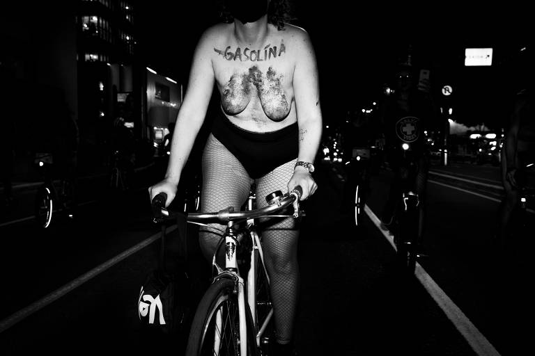 foto em preto e branco de mulher nua pedalando sua bicicleta