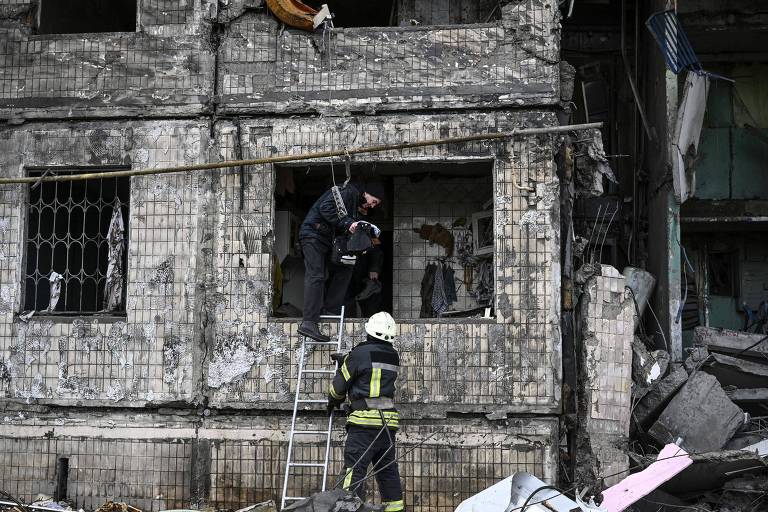 Homem retira pertences de prédio destruído em Kiev, capital da Ucrânia 