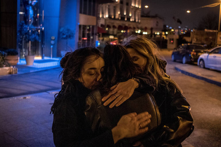 As russas Maria Borzunova e Nigina Beroeva, que trabalhavam na TV russa Chuva, abraçam uma amiga antes de viajar para Tbilisi, na Geórgia