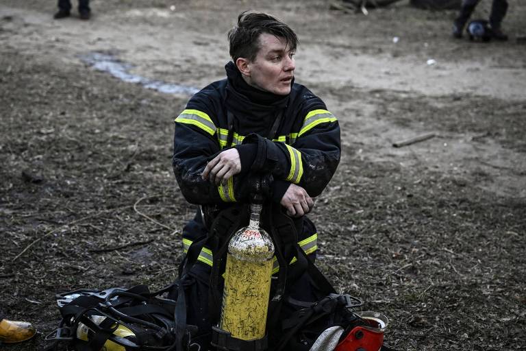 Bombeiro descansa após trabalhar contra incêndio em um prédio de Kiev
