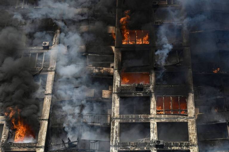 Bombeiros tentam apagar o fogo provocado por um ataque russo em Kiev