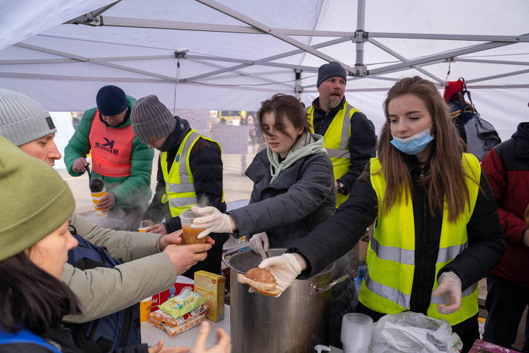 Voluntários colete amarelo fosforescente distribuição comida Ucrânia guerra