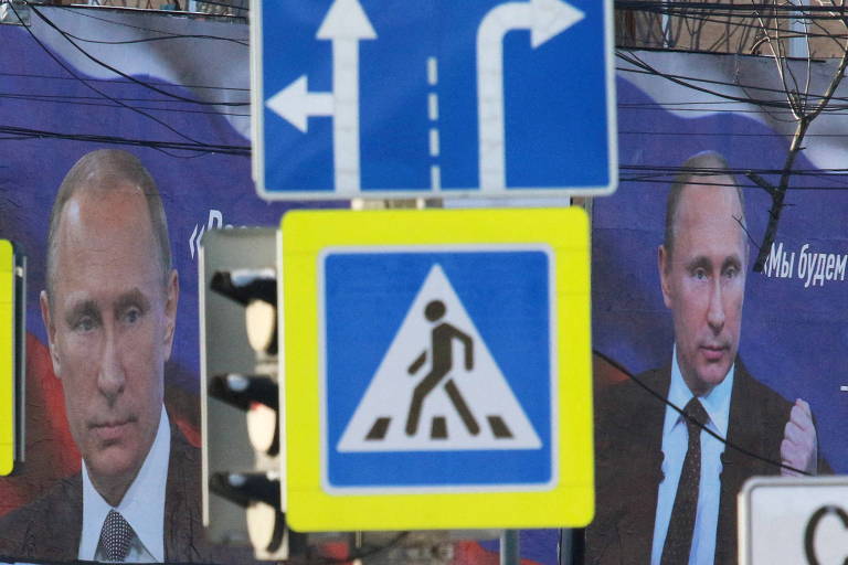 Cartazes com a imagem de um Putin mais jovem em rua de Simferopol, na Crimeia