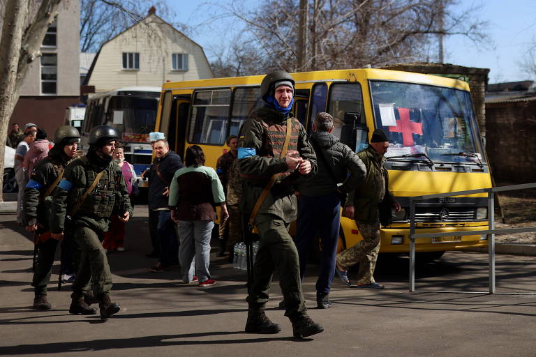 Militares ucranianos passam por um ônibus transformado em ambulância, em Mikolaiv, na Ucrânia