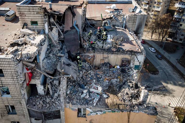 Imagem aérea mostra parte de cima de um prédio destruída. 