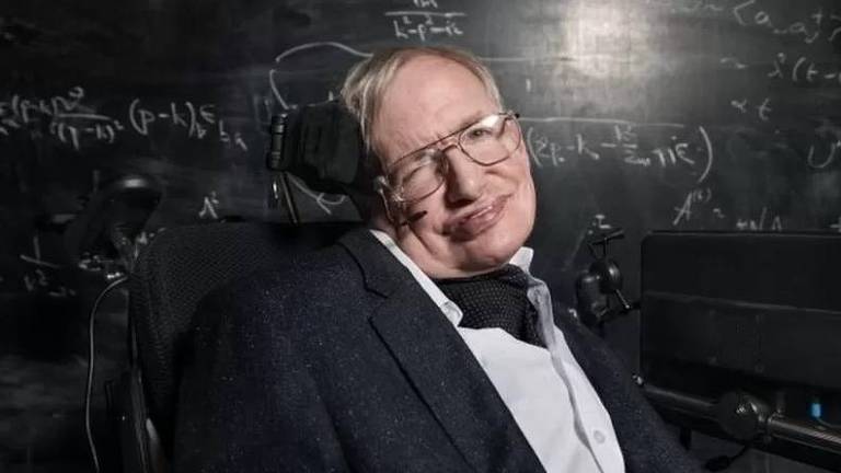 Físico Stephen Hawking em frente a uma lousa com fórmulas matemáticas 