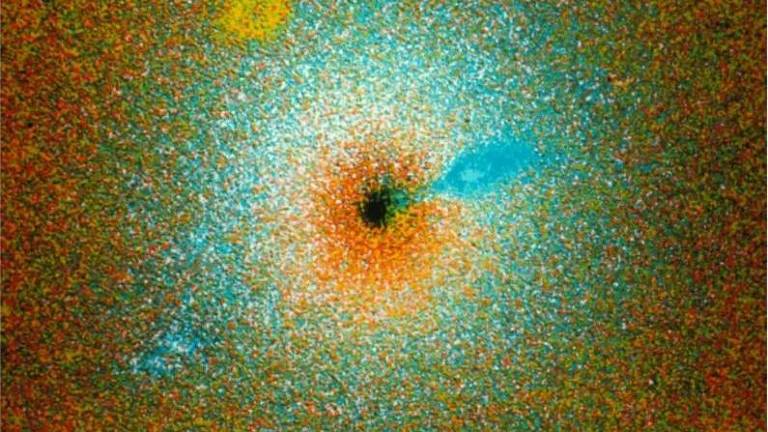 Imagem colorida de uma galáxia, sugerindo que há um buraco negro no centro