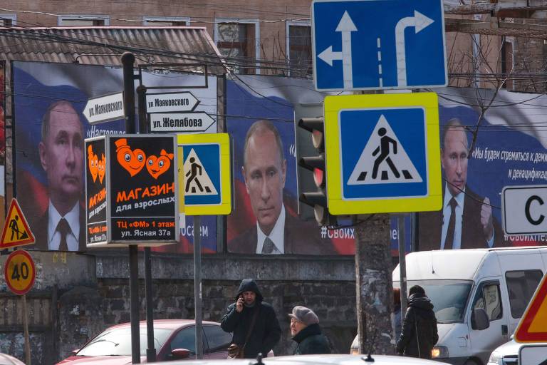 Cartazes com o rosto do presidente Vladimir Putin em meio a placas de trânsito. 