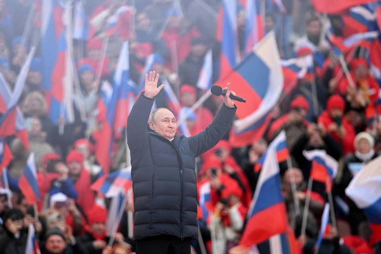 O presidente russo, Vladimir Putin, acena durante evento de celebração da anexação da Ucrânia, no estádio Luzhniki, em Moscou
