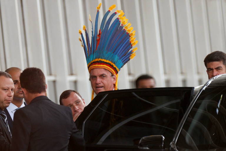 O presidente Jair Bolsonaro usa cocar após cerimônia com indígenas
