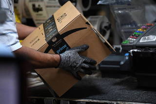 FILE PHOTO: Worker assembles a box for delivery at the Amazon fulfilment center in Baltimore