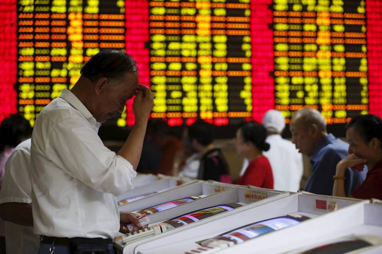 Investors look at computer screens showing stock information at a brokerage house in Shanghai, China, July 8, 2015. Chinese stocks dived on Wednesday after the securities regulator said the tumbling stock market in the world's second-biggest economy was in the grip of &quot;panic sentiment&quot; as investors ignored a battery of support measures from Beijing. REUTERS/Aly Song ORG XMIT: SHA01 LEGENDA DO JORNAL Investidores refor�aram as d�vidas sobre a China
